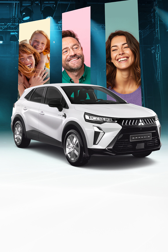 Mitsubishi Grandis Diamant in Weiß in Frontansicht mit drei lächelnden Personen im Hintergrund vor grün-blauem Bühnen-Setting